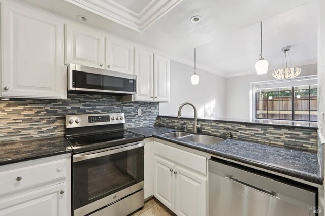 1255 Oak Ridge Ln, Pinole, CA 94564 - kitchen featuring appliances with stainless steel finishes, crown molding, white cabinets, backsplash, and hanging light fixtures