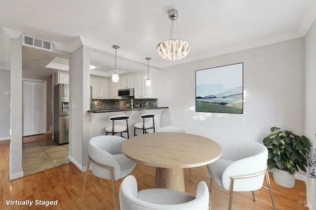 1255 Oak Ridge Ln, Pinole, CA 94564 - dining room with light wood-style flooring, a chandelier, and crown molding