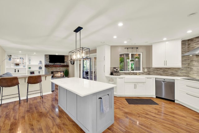 2588 King Edward Ct, El Dorado Hills, CA 95762 - kitchen featuring stainless steel dishwasher, a large fireplace, open floor plan, backsplash, and light countertops