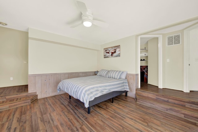 2588 King Edward Ct, El Dorado Hills, CA 95762 - bedroom featuring wainscoting, wood finished floors, wooden walls, and ceiling fan