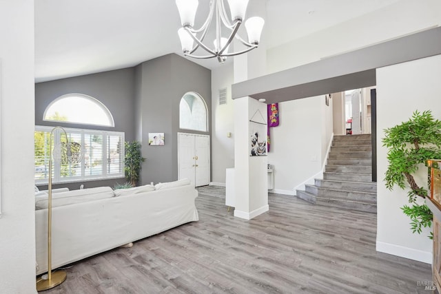 1105 Coulter Ct, Fairfield, CA 94533 - living room featuring high vaulted ceiling, a chandelier, wood finished floors, and stairway