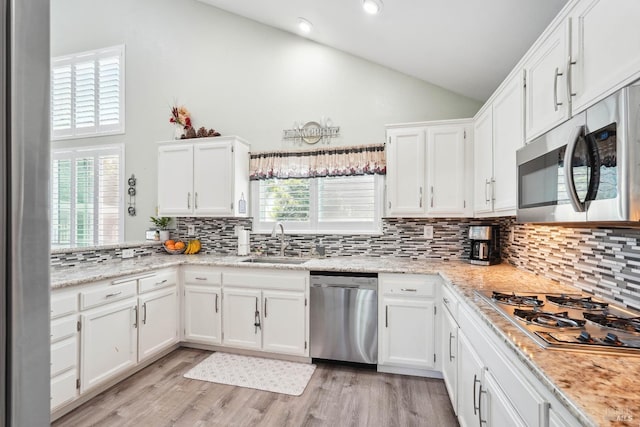 1105 Coulter Ct, Fairfield, CA 94533 - kitchen featuring appliances with stainless steel finishes, white cabinets, plenty of natural light, tasteful backsplash, and high vaulted ceiling