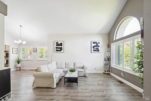 1105 Coulter Ct, Fairfield, CA 94533 - living room with a chandelier, wood finished floors, and high vaulted ceiling