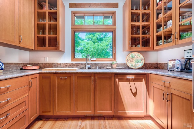 616 Wild Oak Dr, Santa Rosa, CA 95409 - kitchen with brown cabinets, glass insert cabinets, stone countertops, and light wood-style floors