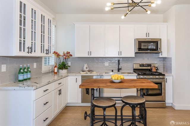 1 Hoffman Ave Unit A, San Francisco, CA 94114 - kitchen featuring stainless steel appliances, a chandelier, light wood finished floors, and white cabinets