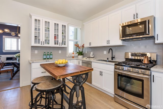 1 Hoffman Ave Unit A, San Francisco, CA 94114 - kitchen featuring stainless steel appliances, light wood-style flooring, white cabinets, and tasteful backsplash