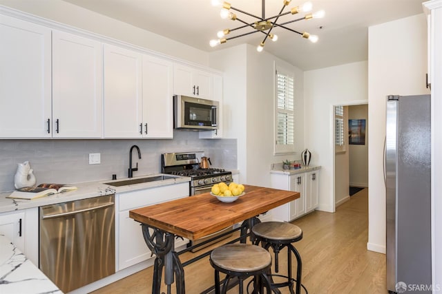 1 Hoffman Ave Unit A, San Francisco, CA 94114 - kitchen with stainless steel appliances, backsplash, a chandelier, and white cabinetry