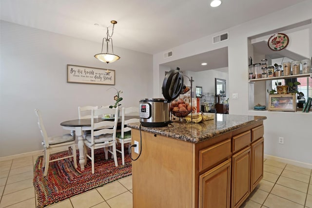 1756 Camino Real Way, Roseville, CA 95747 - kitchen with light tile patterned flooring, dark stone counters, a center island, brown cabinetry, and decorative light fixtures