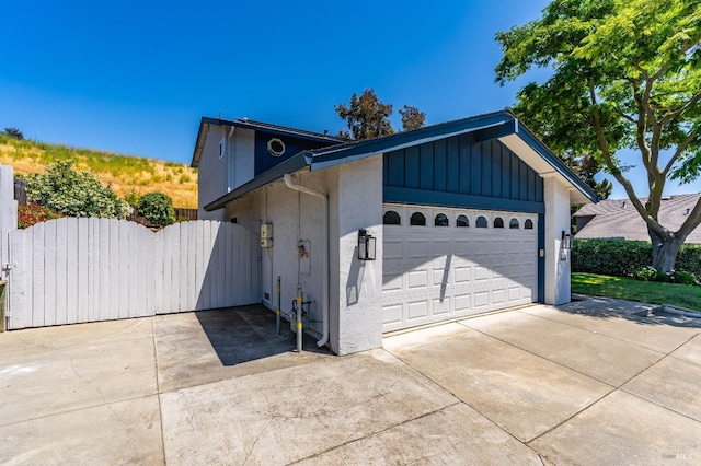 510 Hastings Dr, Benicia, CA 94510 - view of front of house with driveway, an attached garage, a gate, stucco siding, and board and batten siding