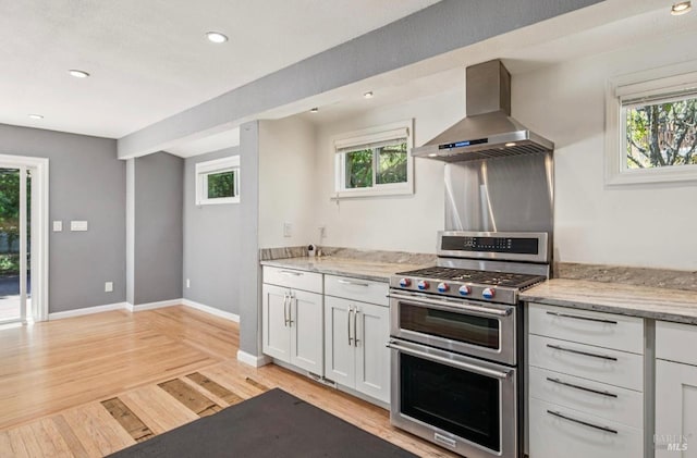 31 Buckelew St, Sausalito, CA 94965 - kitchen featuring wall chimney range hood, range with two ovens, light wood-style flooring, plenty of natural light, and recessed lighting