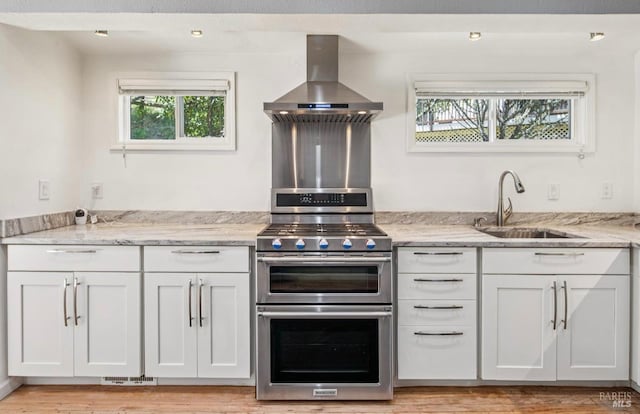 31 Buckelew St, Sausalito, CA 94965 - kitchen with range with two ovens, extractor fan, light stone countertops, and white cabinets