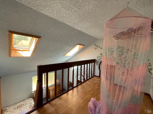 32691 Pearl Dr, Fort Bragg, CA 95437 - hallway featuring a skylight, wood finished floors, lofted ceiling, and a textured ceiling