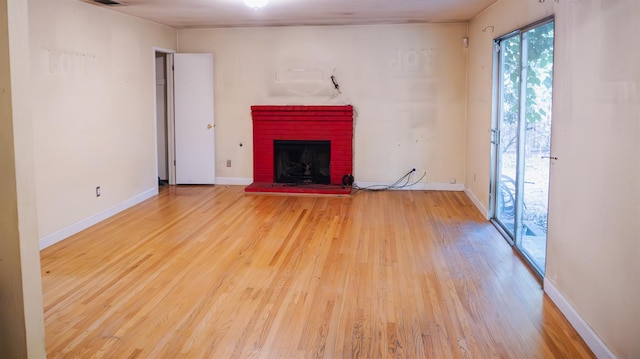 1701 Palm Pl, Davis, CA 95618 - unfurnished living room with wood finished floors and a brick fireplace