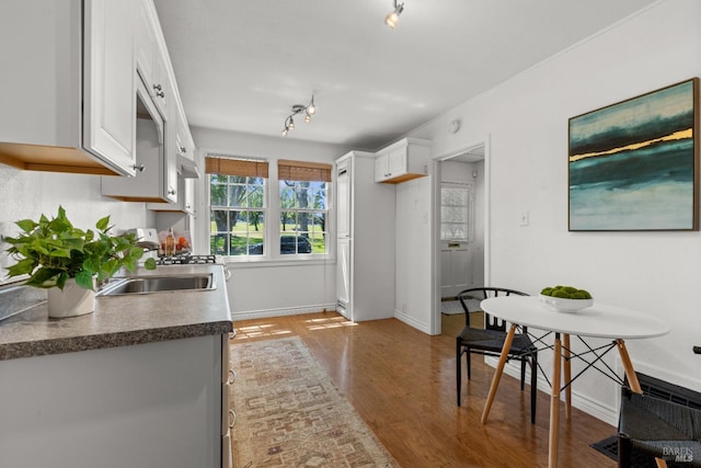 20 Selfridge St, Vallejo, CA 94590 - kitchen with white cabinetry, track lighting, wood finished floors, and dark countertops