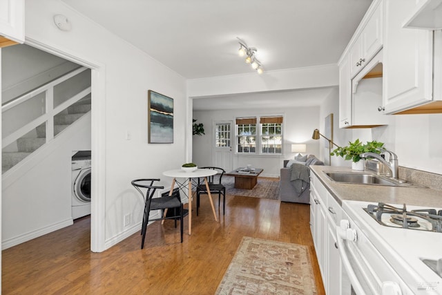 20 Selfridge St, Vallejo, CA 94590 - kitchen featuring washer / clothes dryer, white cabinetry, light wood-type flooring, light countertops, and white gas range