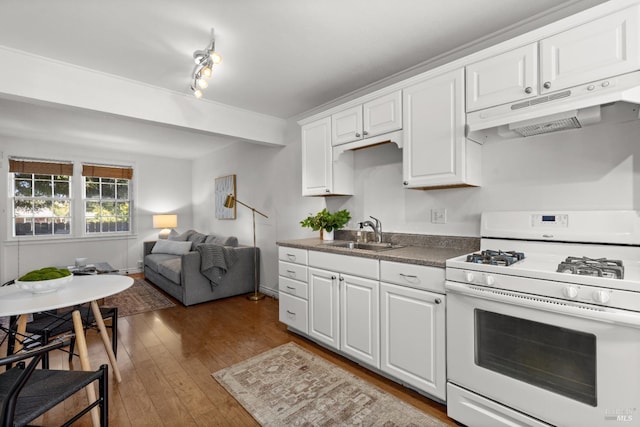 20 Selfridge St, Vallejo, CA 94590 - kitchen with white gas range oven, under cabinet range hood, white cabinetry, wood finished floors, and dark countertops