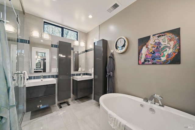 bathroom with two vanities, a freestanding bath, and tile patterned flooring