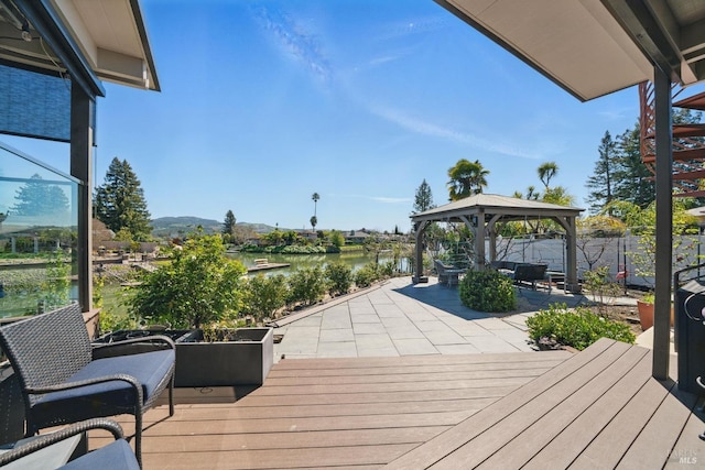 deck featuring a gazebo, a water view, and a patio
