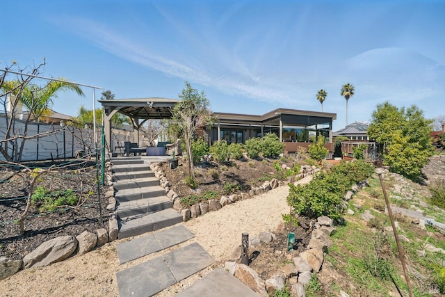 back of property featuring a sunroom and a gazebo