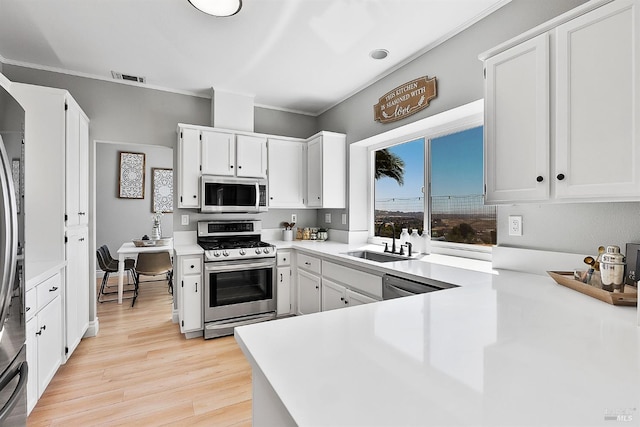 159 Suncliff Pl, Vallejo, CA 94591 - kitchen featuring stainless steel appliances, white cabinetry, light wood-type flooring, light countertops, and ornamental molding