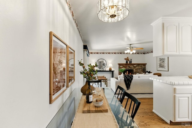 7 Arlene Ct, Petaluma, CA 94952 - dining room featuring ceiling fan, light wood-style flooring, a brick fireplace, and a chandelier