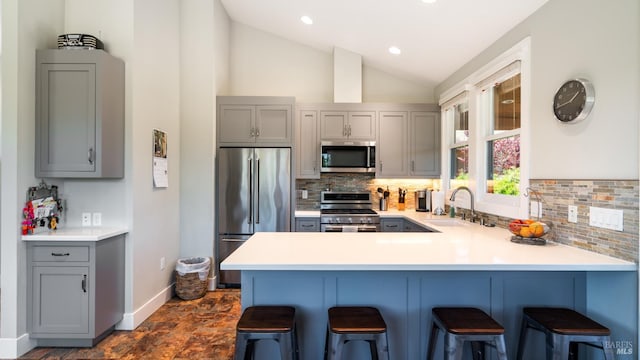2570 Goodwin Ave, Penngrove, CA 94951 - kitchen featuring stainless steel appliances, gray cabinetry, a peninsula, a breakfast bar, and vaulted ceiling