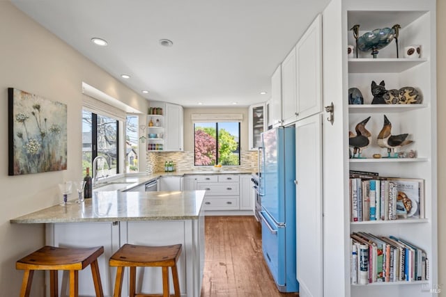 128 Walnut Ave, Mill Valley, CA 94941 - kitchen featuring freestanding refrigerator, a peninsula, open shelves, light stone counters, and light wood-style floors