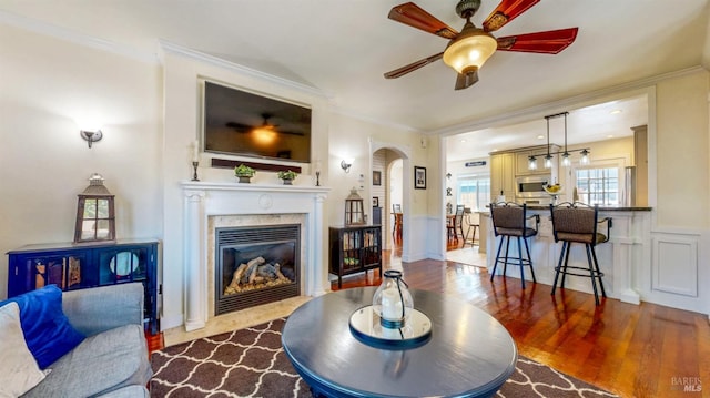 418 W Cotati Ave, Cotati, CA 94931 - living area featuring ceiling fan, arched walkways, a fireplace with flush hearth, wood finished floors, and a wainscoted wall