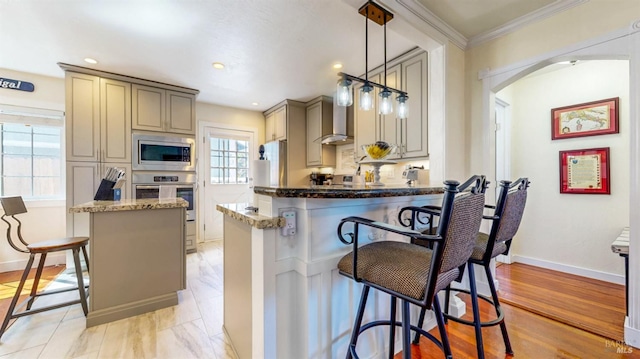 418 W Cotati Ave, Cotati, CA 94931 - kitchen with appliances with stainless steel finishes, dark stone counters, arched walkways, ornamental molding, and a kitchen breakfast bar