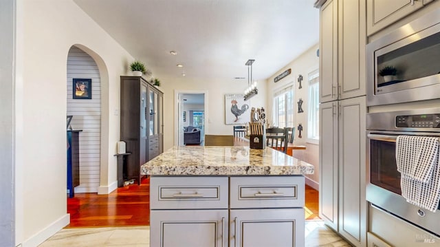 418 W Cotati Ave, Cotati, CA 94931 - kitchen with appliances with stainless steel finishes, gray cabinetry, light stone countertops, arched walkways, and a kitchen island