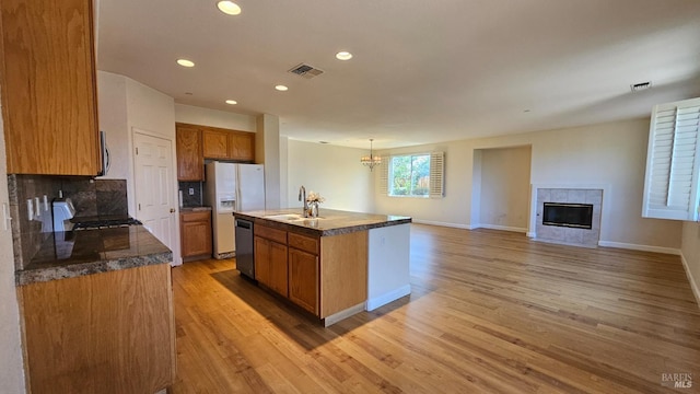 27 Via La Morra, American Canyon, CA 94503 - kitchen with appliances with stainless steel finishes, light wood finished floors, a tiled fireplace, recessed lighting, and brown cabinets