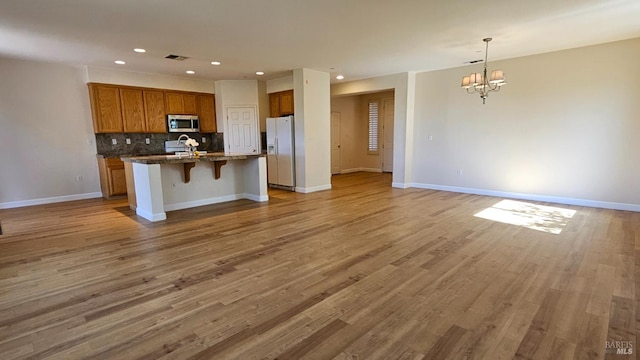 27 Via La Morra, American Canyon, CA 94503 - kitchen with stainless steel microwave, white refrigerator with ice dispenser, open floor plan, a chandelier, and brown cabinets