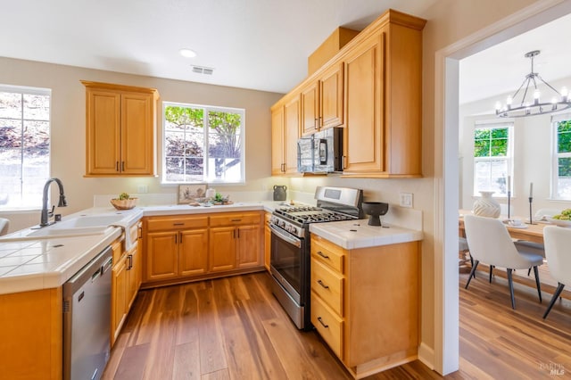 339 Sterling Way, San Rafael, CA 94903 - kitchen with stainless steel appliances, tile counters, wood-type flooring, a chandelier, and recessed lighting