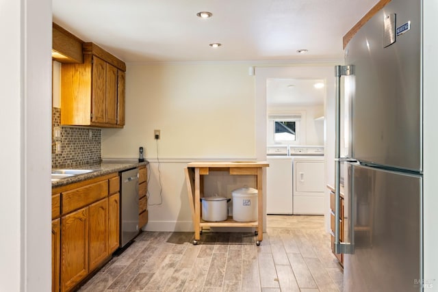 9748 Middle Creek Rd, Upper Lake, CA 95485 - kitchen featuring stainless steel appliances, separate washer and dryer, brown cabinetry, light wood-style flooring, and ornamental molding