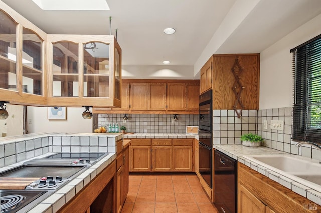 7 Shanley Ln, Ross, CA 94957 - kitchen featuring tile counters, black appliances, a skylight, light tile patterned floors, and recessed lighting