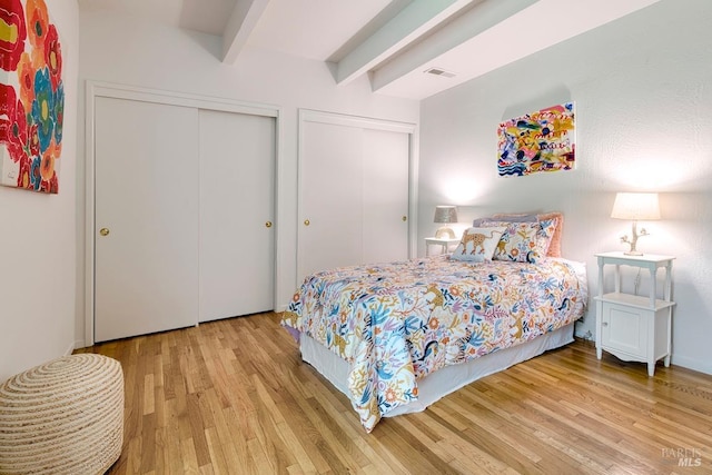 173 Marina Vista Ave, Larkspur, CA 94939 - bedroom featuring multiple closets, beamed ceiling, and wood finished floors