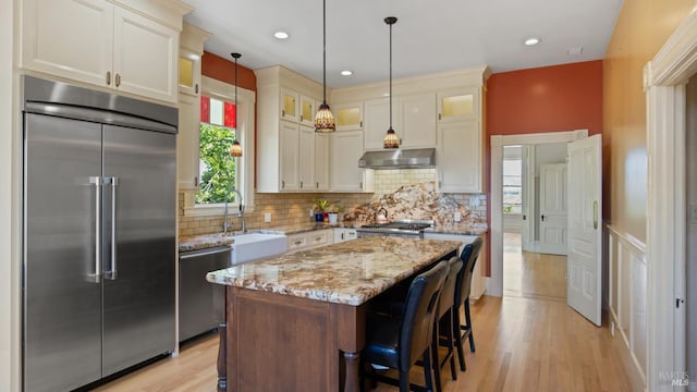 623 Keller St, Petaluma, CA 94952 - kitchen with stainless steel appliances, under cabinet range hood, tasteful backsplash, light wood finished floors, and glass insert cabinets