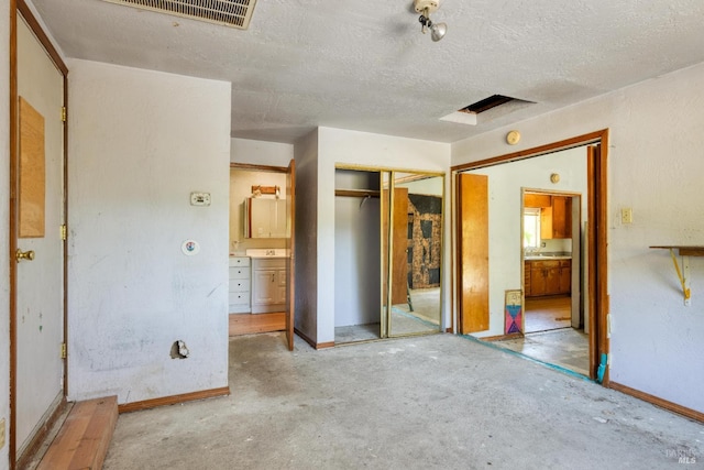 1415 Schaeffer Rd, Sebastopol, CA 95472 - unfurnished bedroom featuring a closet, unfinished concrete floors, ensuite bathroom, and a textured ceiling