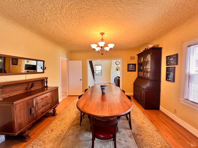 436 S Front St, Rio Vista, CA 94571 - dining space featuring a chandelier, light wood-type flooring, a textured ceiling, and healthy amount of natural light