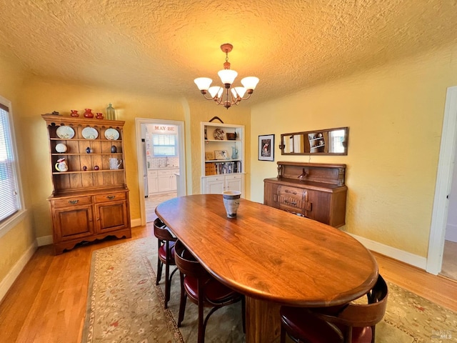 436 S Front St, Rio Vista, CA 94571 - dining area with a chandelier, light wood finished floors, and a textured ceiling