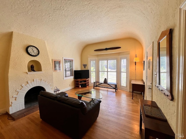 436 S Front St, Rio Vista, CA 94571 - living room with a textured wall, wood finished floors, a textured ceiling, a fireplace, and vaulted ceiling