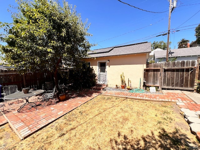 436 S Front St, Rio Vista, CA 94571 - rear view of house with stucco siding, solar panels, a patio area, and a shingled roof