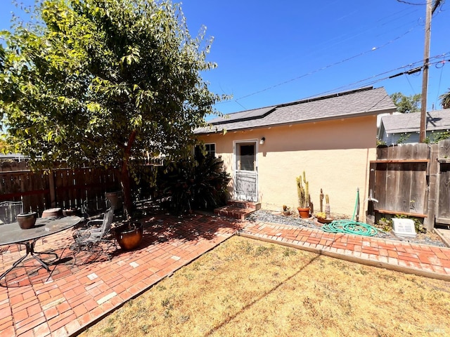 436 S Front St, Rio Vista, CA 94571 - rear view of property with stucco siding, roof mounted solar panels, a patio area, and roof with shingles