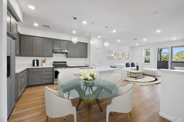 40708 Fremont Blvd, Fremont, CA 94538 - kitchen featuring stainless steel appliances, gray cabinetry, light countertops, under cabinet range hood, and light wood finished floors