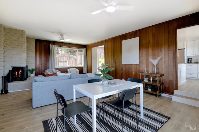 76 Oak Springs Dr, San Anselmo, CA 94960 - dining space featuring ceiling fan, wood walls, light wood finished floors, and a fireplace