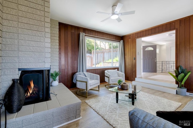 76 Oak Springs Dr, San Anselmo, CA 94960 - living room featuring wooden walls, light wood finished floors, a ceiling fan, and a brick fireplace