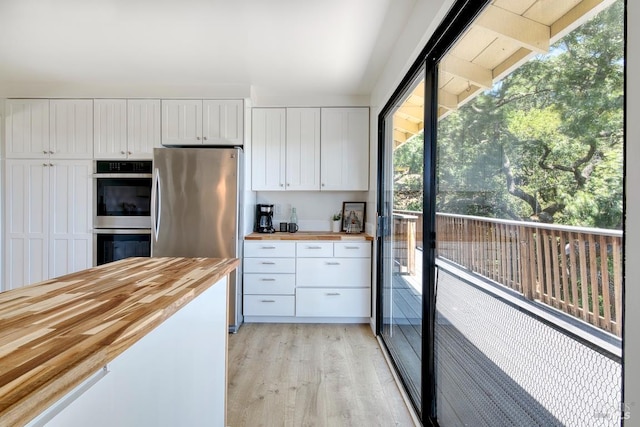 76 Oak Springs Dr, San Anselmo, CA 94960 - kitchen with butcher block countertops, appliances with stainless steel finishes, light wood finished floors, and white cabinets