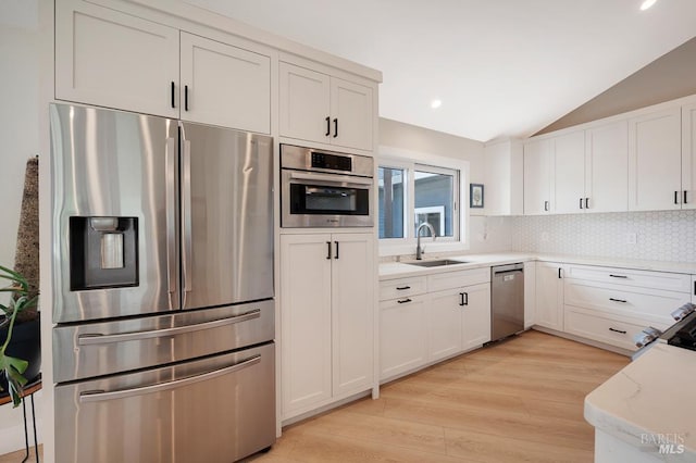 5648 Ver Ni Rd, Sebastopol, CA 95472 - kitchen with appliances with stainless steel finishes, vaulted ceiling, backsplash, light wood-style flooring, and white cabinetry
