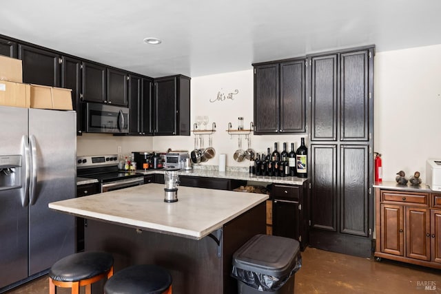 875 White Cottage Rd N, Angwin, CA 94508 - kitchen with stainless steel appliances, a breakfast bar, dark cabinets, concrete floors, and a center island