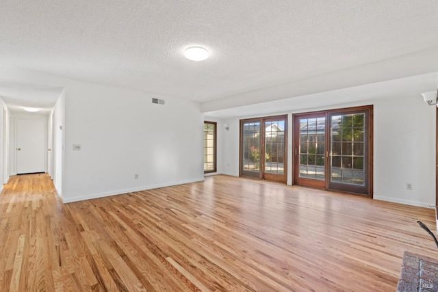 437 Ely Blvd S, Petaluma, CA 94954 - unfurnished living room featuring a textured ceiling, light wood-style floors, and healthy amount of natural light